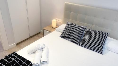 Un dormitorio con una cama blanca con toallas. en Caminando al Guggenheim by Urban Hosts, en Bilbao