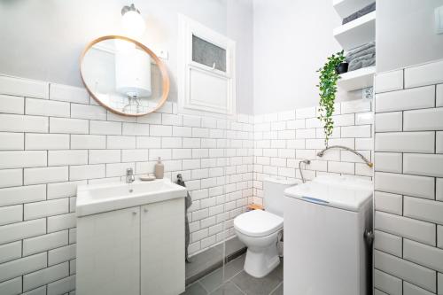 a bathroom with a toilet and a sink and a mirror at Cozy apartment in Budapest near Gellért Hill in Budapest