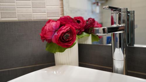a vase with a red flower sitting on a sink at Cozy studio with a sea view in Nice