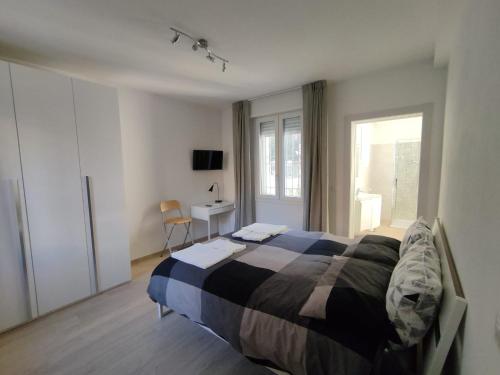 a bedroom with a bed and a desk and a window at Grigio Perla Panigale, villetta con giardino e parcheggio privato gratuito in Bologna