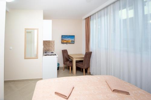 a bedroom with a bed and a desk and a table at Apartment Sofija in Budva