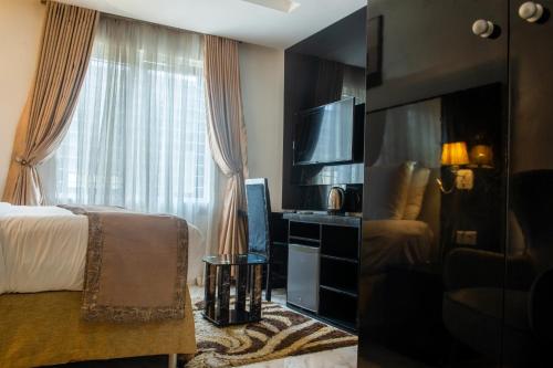 Habitación de hotel con cama y TV en Ziroc Residence Lekki Phase 1, en Lekki