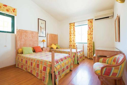 ヴィラモウラにあるBelo Florのベッドルーム1室(ベッド2台、テーブル、椅子付)