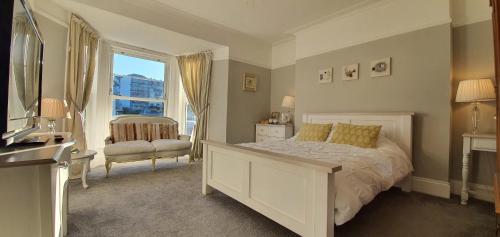 a bedroom with a bed and a chair and a window at Rocky Cove Bed and Breakfast in Ilfracombe