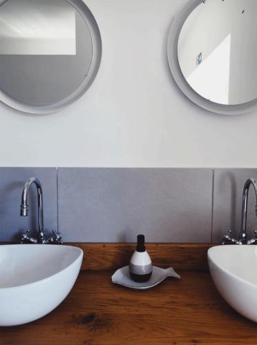 a bathroom with two sinks and two mirrors at Vintage tent at the Lovsin Estate in Metlika