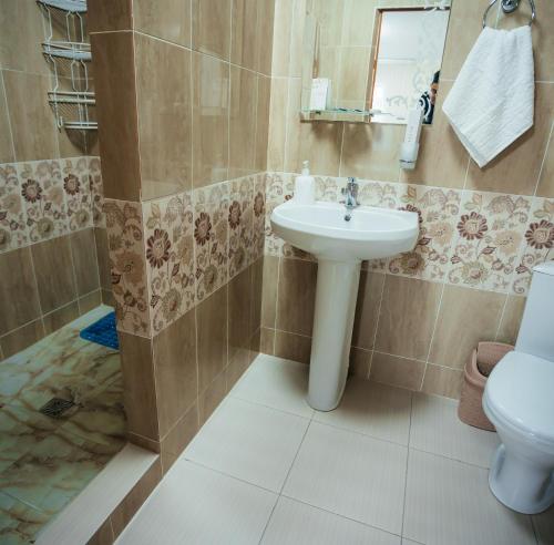 a bathroom with a sink and a toilet at Hotel Дар-Ай in Kostanay