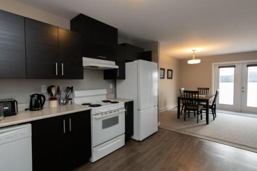 a kitchen with black cabinets and a white refrigerator at The Killick Inn & Suites in Arnold's Cove
