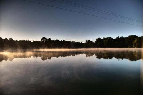 a misty lake with trees in the background at Dahu Wake Park, proche Saint Emilion in Sablons