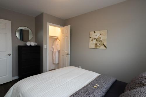 a bedroom with a white bed and a mirror at The Killick Inn & Suites in Arnold's Cove