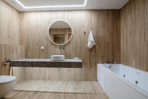 a bathroom with a sink and a tub and a mirror at Hotel Jarzębata in Wisła