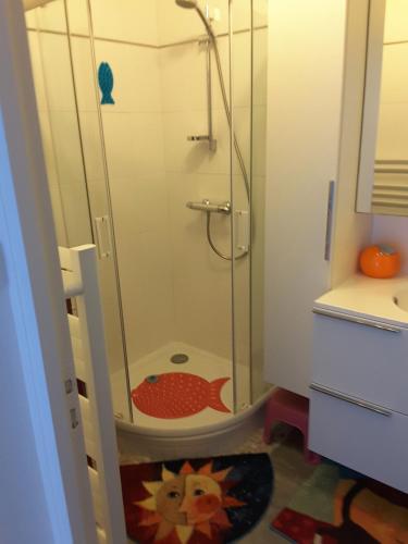 une douche avec une porte vitrée dans une salle de bain dans l'établissement Les sables d’or, à Saint-Jean-de-Monts