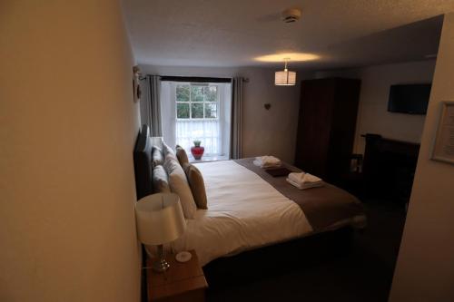 a bedroom with a large bed with a window at The George Inn in Castleton