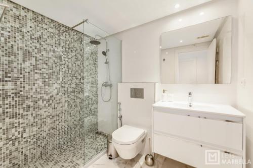 y baño con aseo, lavabo y ducha. en LetsMarbella - NEW 2BR APARTMENT IN PUERTO BANUS - POOL & PARKING, en Marbella