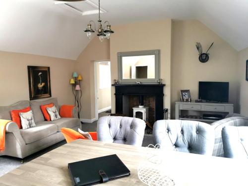 a living room with a table and chairs and a fireplace at The Courtyard Apartment at Cefn Tilla Court, Usk in Usk