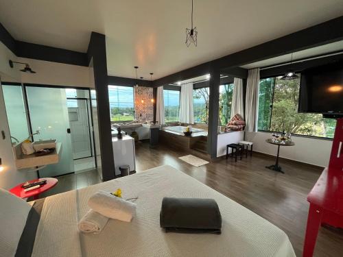 a living room with a large room with a large window at Solar das Aroeiras in Serra do Cipo