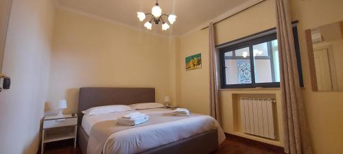 um pequeno quarto com uma cama e uma janela em Manzoni Apartment em Messina