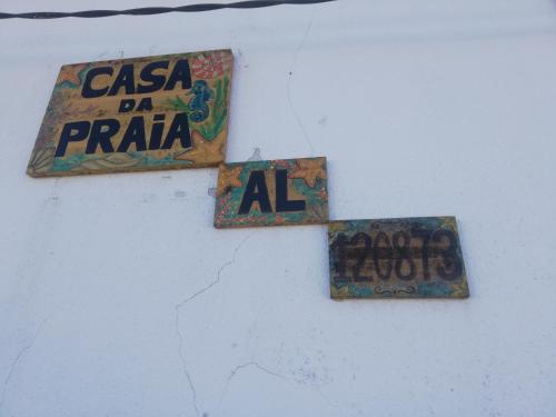 three signs on a wall with graffiti on it at Casa da Praia Alfarim in Sesimbra