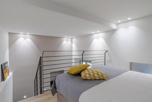 una camera da letto con un letto con cuscini gialli di Suite Roma - by MyHomeInComo a Como