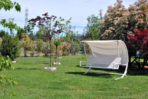 a white chair sitting in the grass in a field at Hotel Villa Costanza in Pontenure