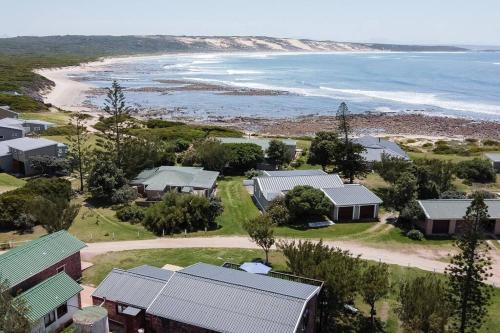 uma vista aérea das casas e da praia em Kanon Private Nature Reserve em Mossel Bay