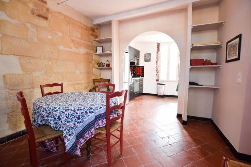 uma sala de jantar com uma mesa e uma parede de pedra em Micoulet, Parking - Clim em Arles