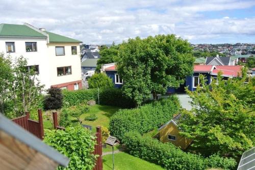 een uitzicht op een tuin met een huis bij Tórshavn - Central - City & Ocean Views - 3BR in Tórshavn