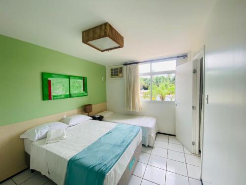 um quarto de hotel com duas camas e uma janela em Gran lençóis flat Residence em Barreirinhas