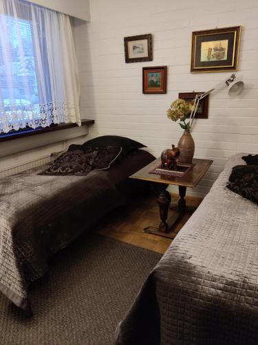 a bedroom with two beds and a table and a window at Apartment Nonna in Keuruu