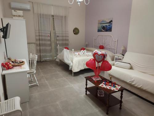 a living room with a couch and a table with a heart balloon at B&B Petra Hercules in Torre Annunziata