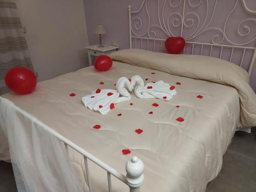 a white bed with red hearts on it at B&B Petra Hercules in Torre Annunziata