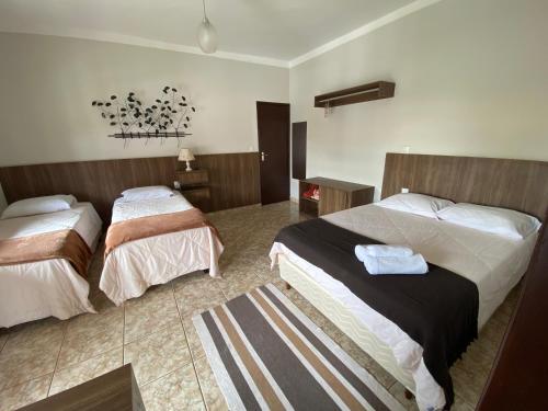 a hotel room with two beds and a rug at Solar da Vila in Tiradentes