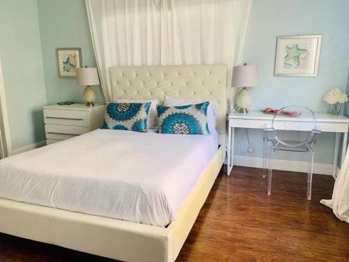 a bedroom with a large white bed and a desk at Sun Sand and Love - Lovely 2 Beds, 2 Bath Condo in Miami Beach