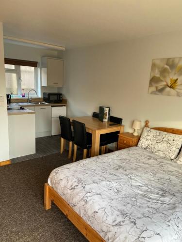 a bedroom with a bed and a kitchen with a table at Forest Edge Motel in Ticehurst