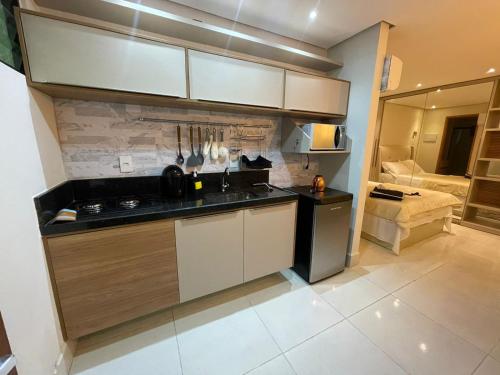 uma cozinha com um lavatório e um fogão forno superior em Flat encantador em Bananeiras PB em Bananeiras