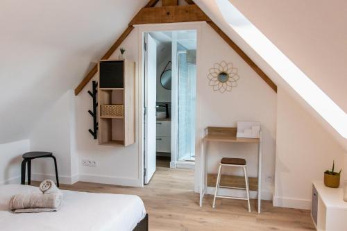 Habitación con cama y escritorio en el ático en Confortable T1bis rénové, au cœur d'un bourg calme, en La Chapelle-Neuve
