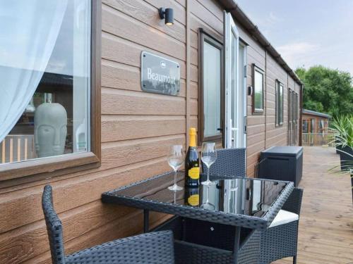 a table with two glasses of wine on a patio at 2 Bed Lodge - Sleeps 6 - Dogs - Hot Tub - Parking in Bridlington