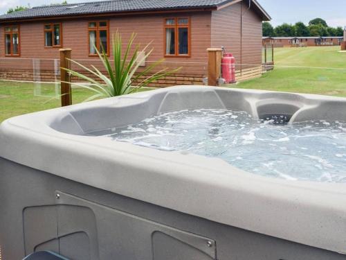 a large hot tub in a yard with a house at 2 Bed Lodge - Sleeps 6 - Dogs - Hot Tub - Parking in Bridlington