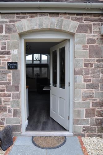 an open door into a brick building with aphalt at Cecile's Cottage at Cefn Tilla Court, Usk in Usk