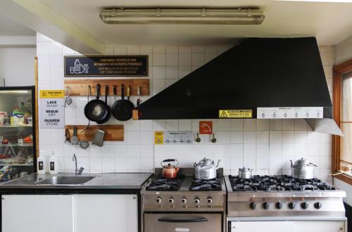 a kitchen with a stove and a sink and a counter top at YAGHAN HOSTEL in Ushuaia