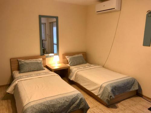 瓦爾納的住宿－Ssenyange Guest House，配有镜子的客房内的两张床
