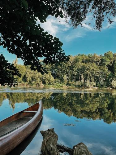 a boat on a lake with trees in the background at Vintage tent at the Lovsin Estate in Metlika