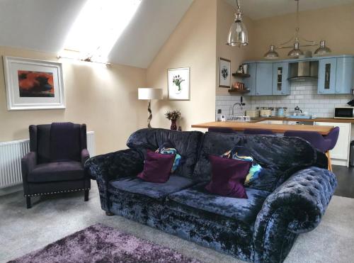 a living room with a couch and a chair at The Coach House Apartment at Cefn Tilla Court, Usk in Usk