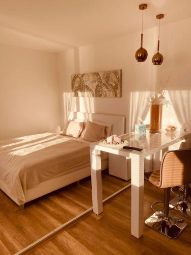 a bedroom with a bed and a table and a desk at Trio Apartments in Ostrava