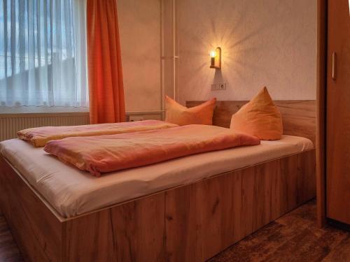 バート・シャンダウにあるFerienappartements Elbaussicht - Krippenのベッドルーム1室(オレンジ色の枕が備わるベッド2台付)