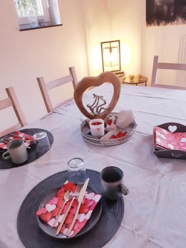 a table with a plate of food and a heart on it at B&B Caprice d'Epices in Francorchamps