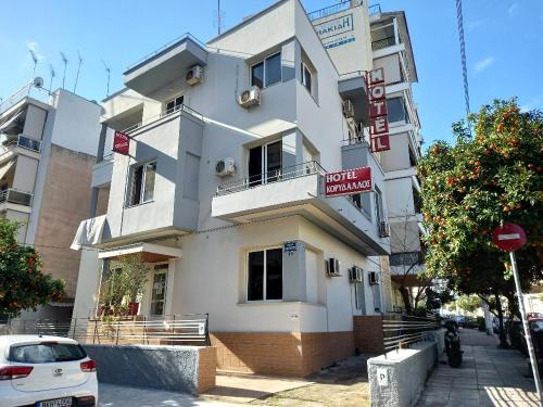 a white building with a sign in front of it at Hotel Korydallos in Piraeus