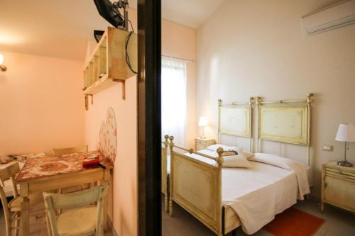 a bedroom with a bed and a table and a desk at Lucciole Nella Nebbia in Stellata