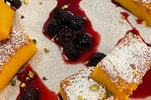 a plate of desserts with blueberries and powdered sugar at Lucciole Nella Nebbia in Stellata