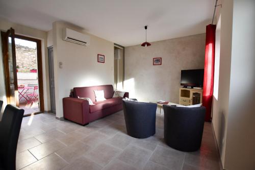 un salon avec un canapé, des chaises et une télévision dans l'établissement Coulège - Clim - Cour, à Arles