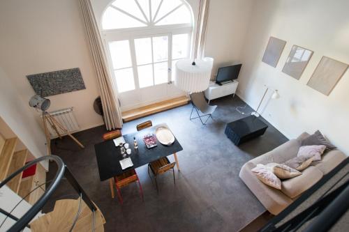 vista sul soffitto di un soggiorno con divano e tavolo di Divonne - Loft cosy avec jardin partagé a Arles